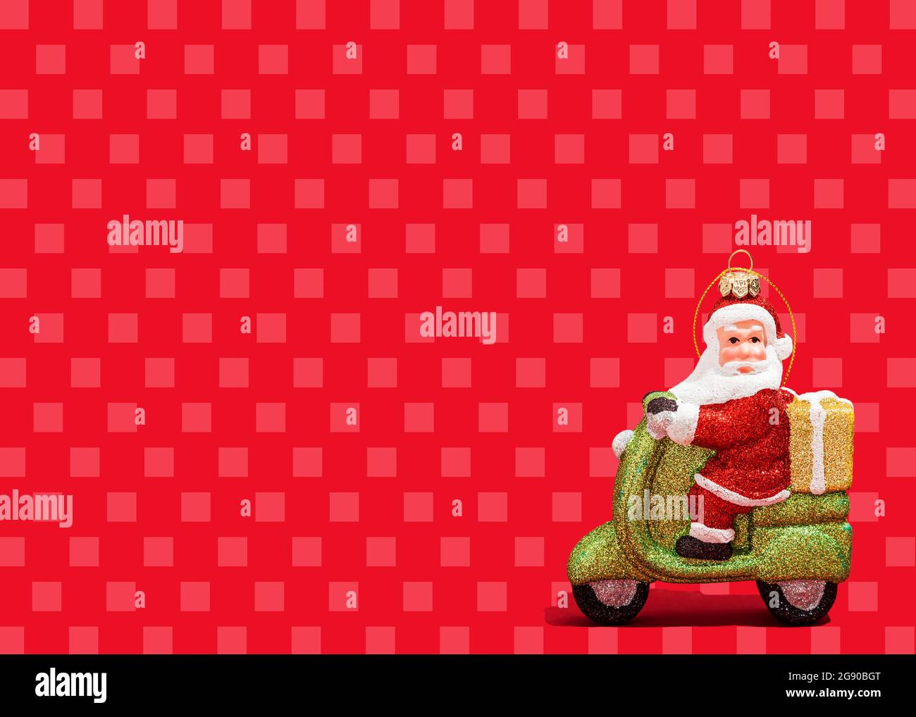 Décoration de Noël du scooter des roues du Père Noël sur fond rouge vif à carreaux Banque D'Images