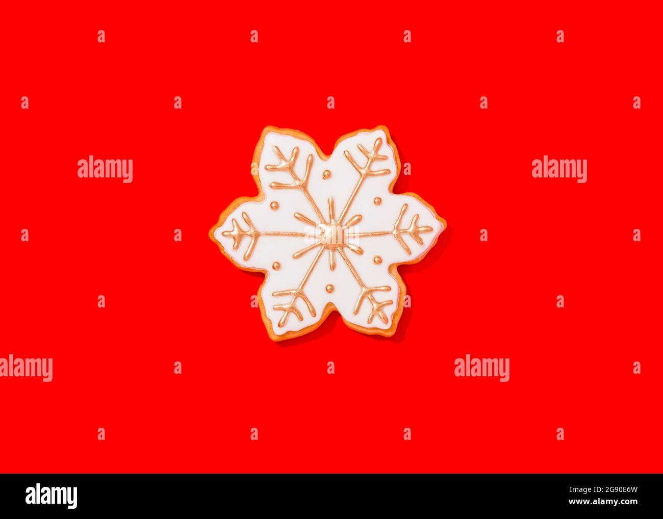 Biscuit de Noël en forme de flocons de neige sur fond rouge vif Banque D'Images