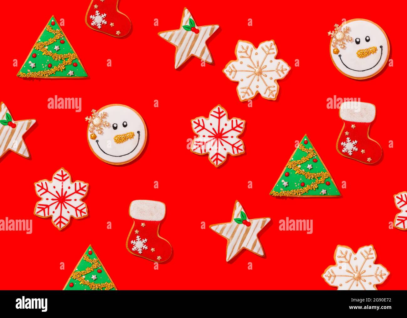 Motif de divers biscuits de Noël posés à plat sur fond rouge vif Banque D'Images