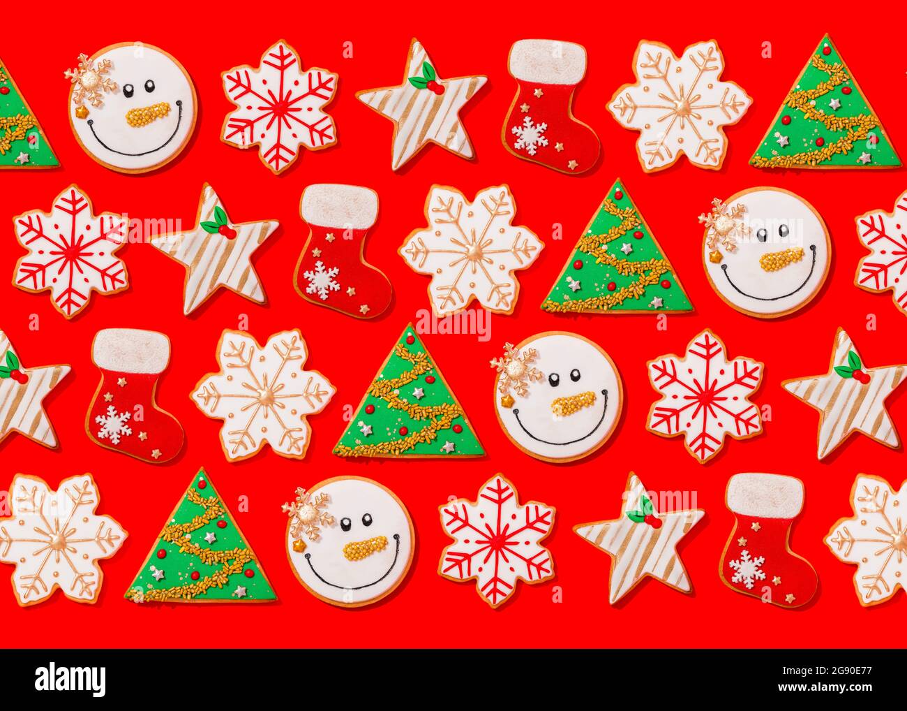 Motif de divers biscuits de Noël posés à plat sur fond rouge vif Banque D'Images