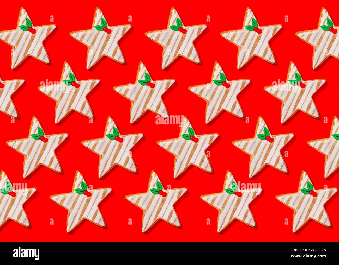 Motif de biscuits de Noël en forme d'étoiles posé sur fond rouge vif Banque D'Images