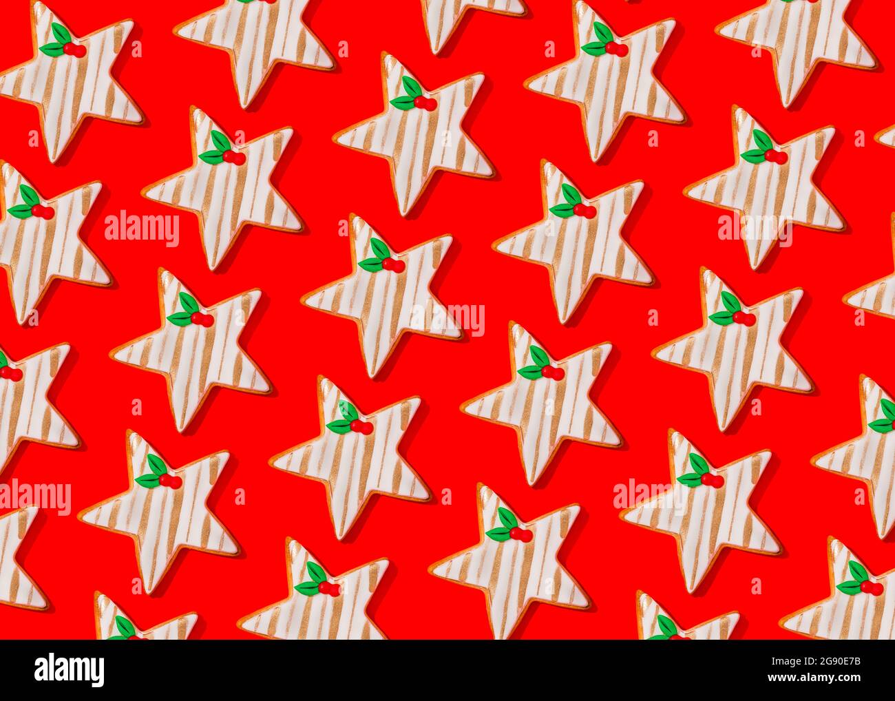 Motif de biscuits de Noël en forme d'étoiles posé sur fond rouge vif Banque D'Images