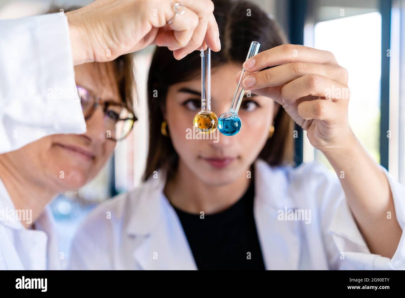 Femmes scientifiques examinant des produits chimiques dans des tubes à essai en laboratoire Banque D'Images
