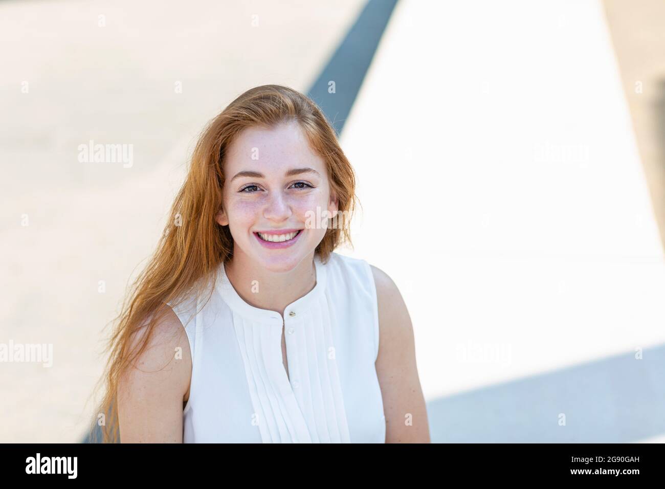 Belle femme d'affaires à tête rouge souriant pendant la journée ensoleillée Banque D'Images