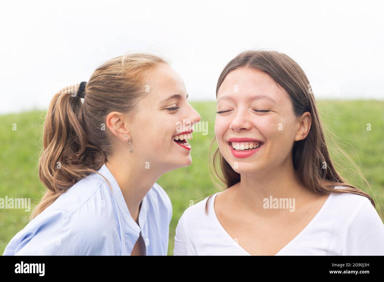 Des amies féminines heureuses avec les yeux fermés persiflage dans la nature Banque D'Images