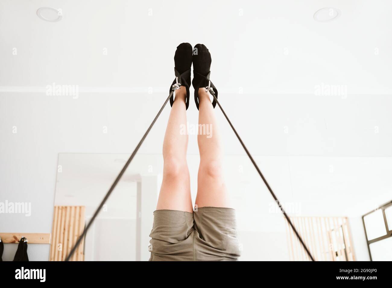 Homme qui fait la jambe en pratiquant des pilates en studio Banque D'Images