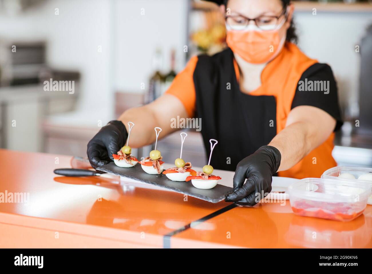 Chef féminin tenant un tableau de service au comptoir de la cafétéria Banque D'Images Chef féminin tenant un tableau de service au comptoir de la cafétéria Banque D'Images