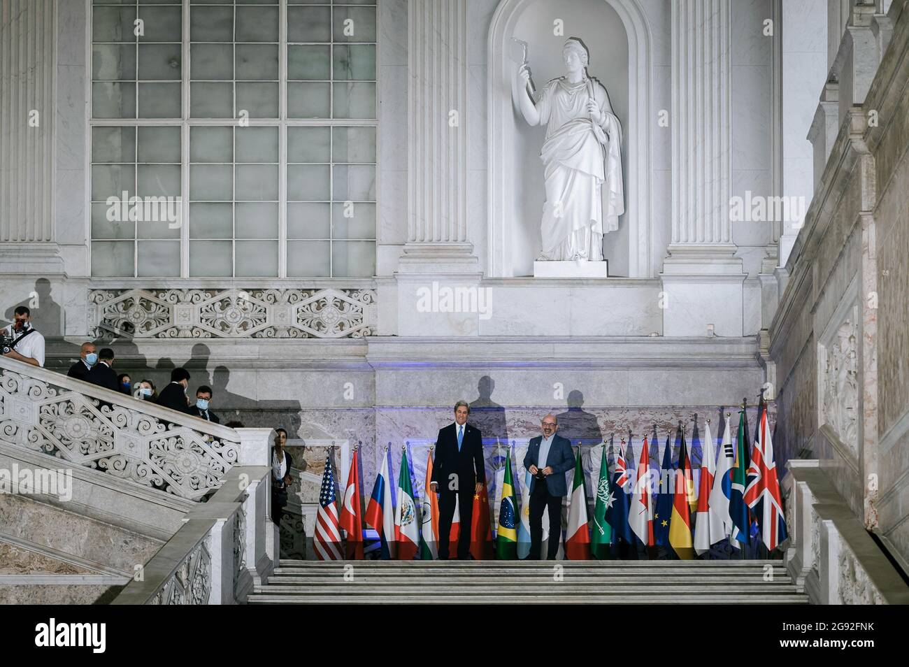 Naples, Italie. 23 juillet 2021. John Kerry (L), l'envoyé spécial présidentiel américain pour le climat et le ministre italien de la transition écologique Roberto Cingolani (R) posent pour des photographies devant les drapeaux des pays du G20. Le ministre italien de la transition écologique Roberto Cingolani a présidé la réunion ministérielle conjointe du G20 sur l'environnement, le climat et l'énergie, le deuxième jour à Naples, organisée dans le cadre de la présidence italienne du G20. La réunion, qui s'est tenue au Palais Royal, a vu la participation d'orateurs principaux venus des pays du G20 et de plusieurs INS internationaux Banque D'Images