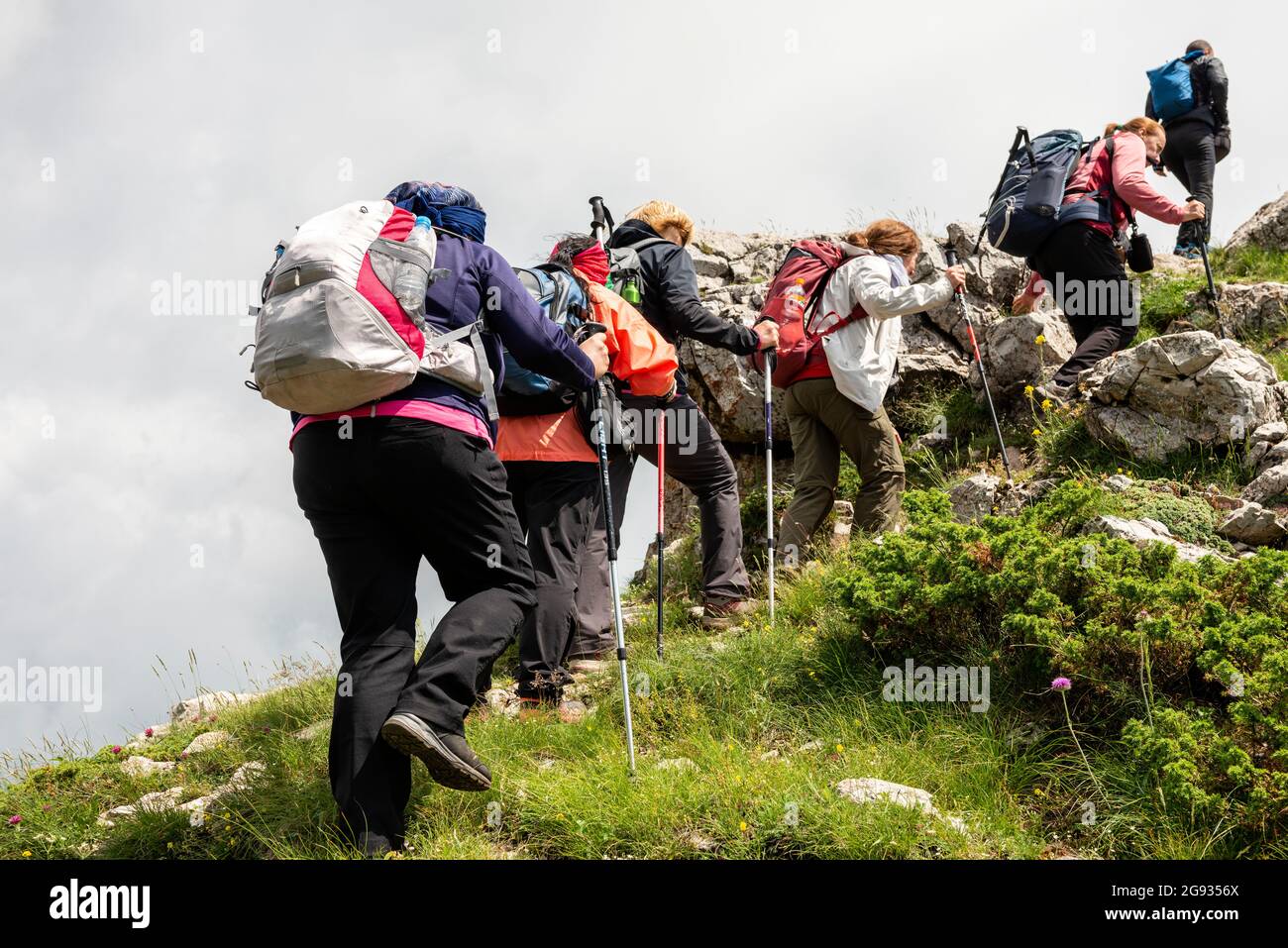 Groupe de randonneurs femelles traversant le mur des chèvres ou le mur Chamois sur le sentier européen de la route piétonne E-3, réserve de biosphère de l'UNESCO, Bulgarie Banque D'Images