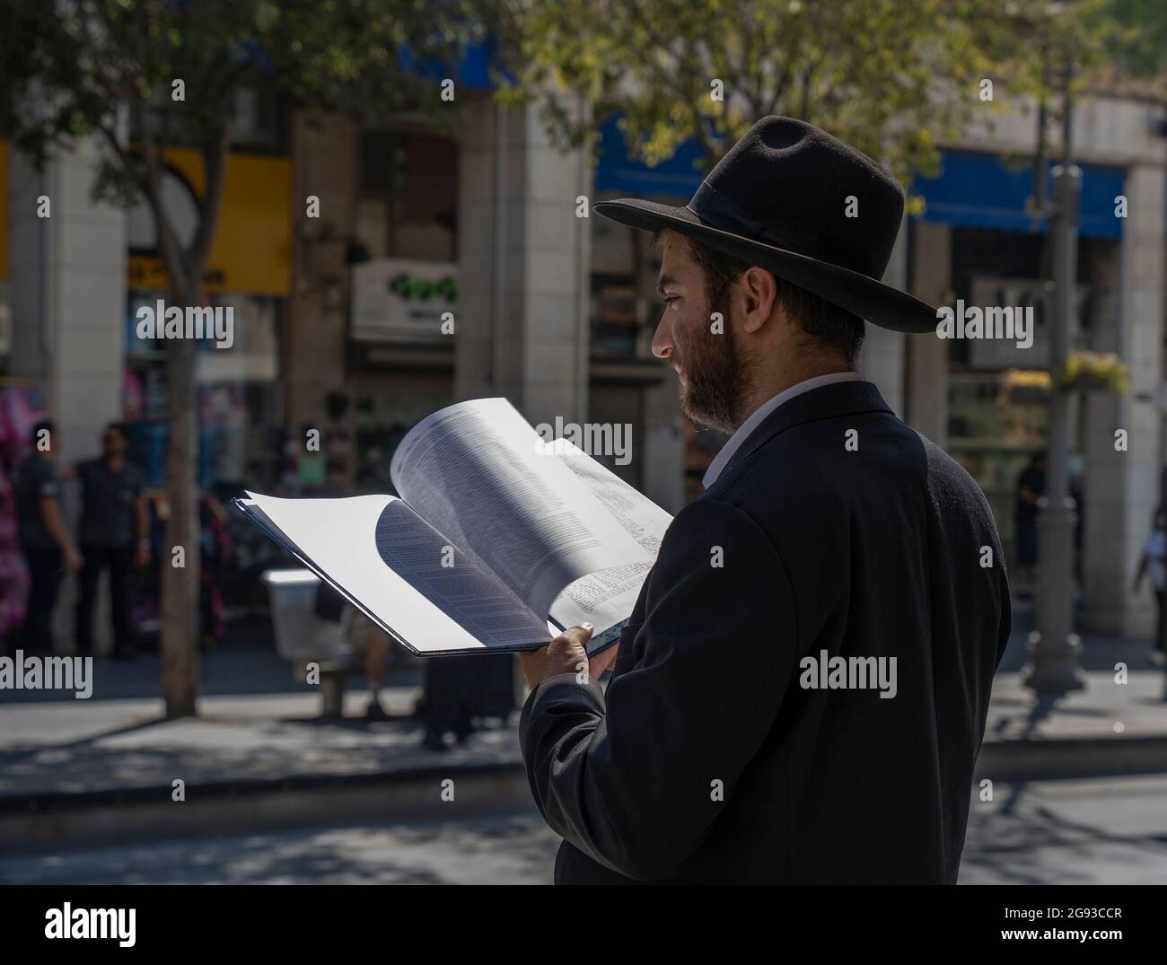 Jérusalem, Israël - 21 juillet 2021 : un juif orthodoxe lisant un livre de Mishna sur une rue de Jérusalem, Israël, un jour ensoleillé. Banque D'Images