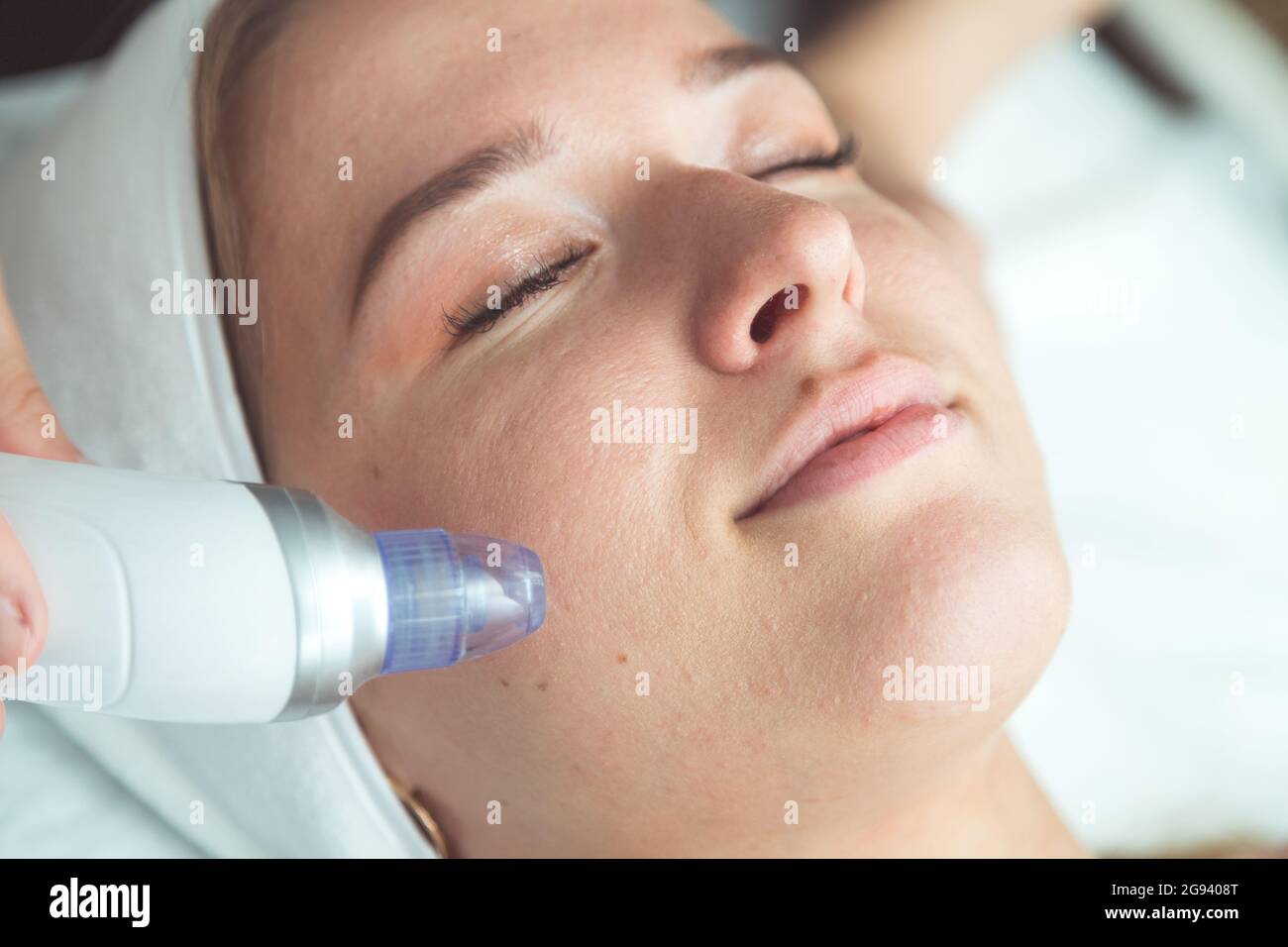 gros plan portrait d'une femme heureuse à tête rouge avec les yeux fermés obtenant rf-levage dans un salon de beauté Banque D'Images