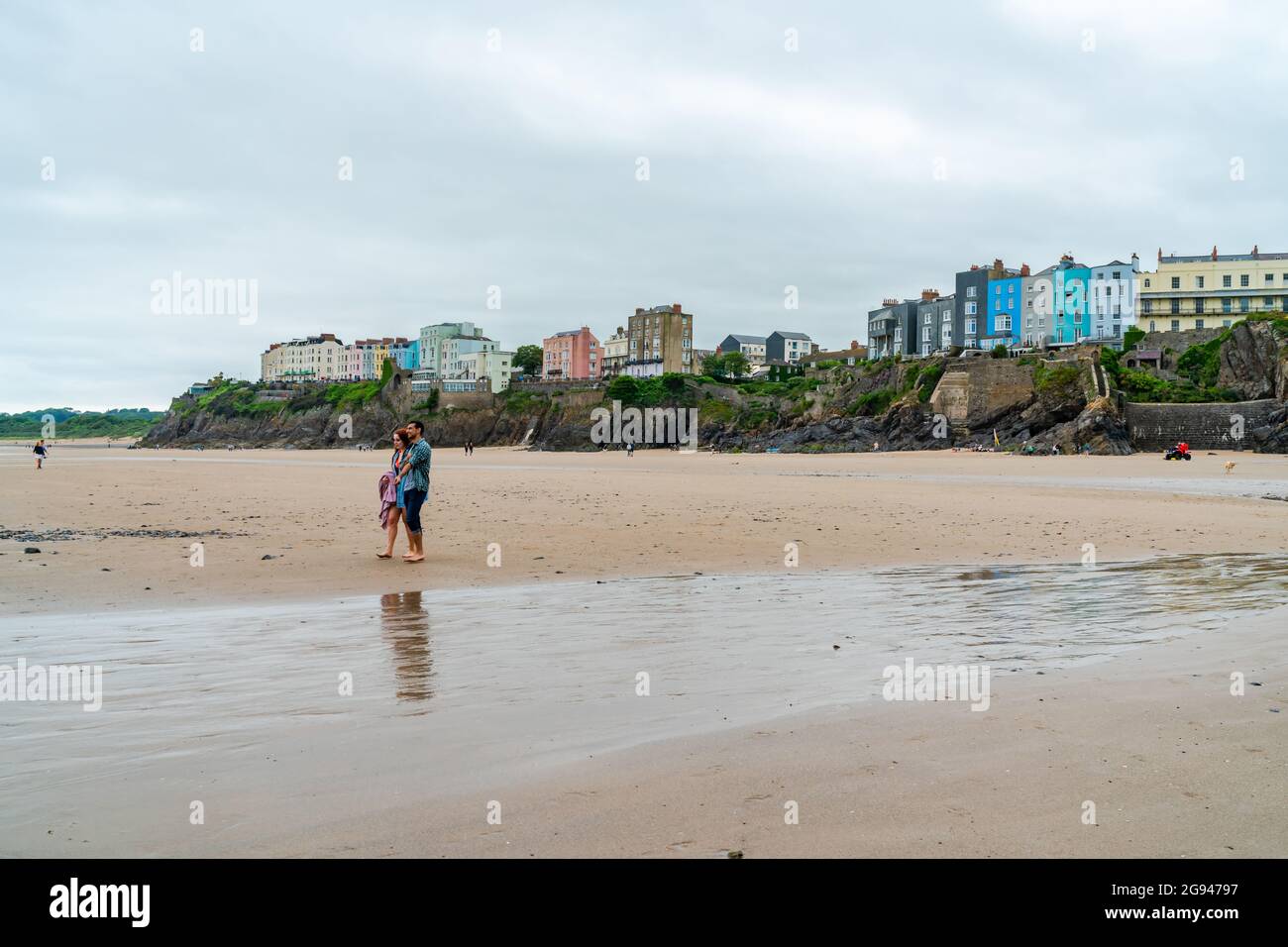 TENBY, PAYS DE GALLES - 28 JUIN 2021 : les gens se promènent le long d'une plage de sable à Tenby, dans le sud-ouest du pays de Galles. Banque D'Images