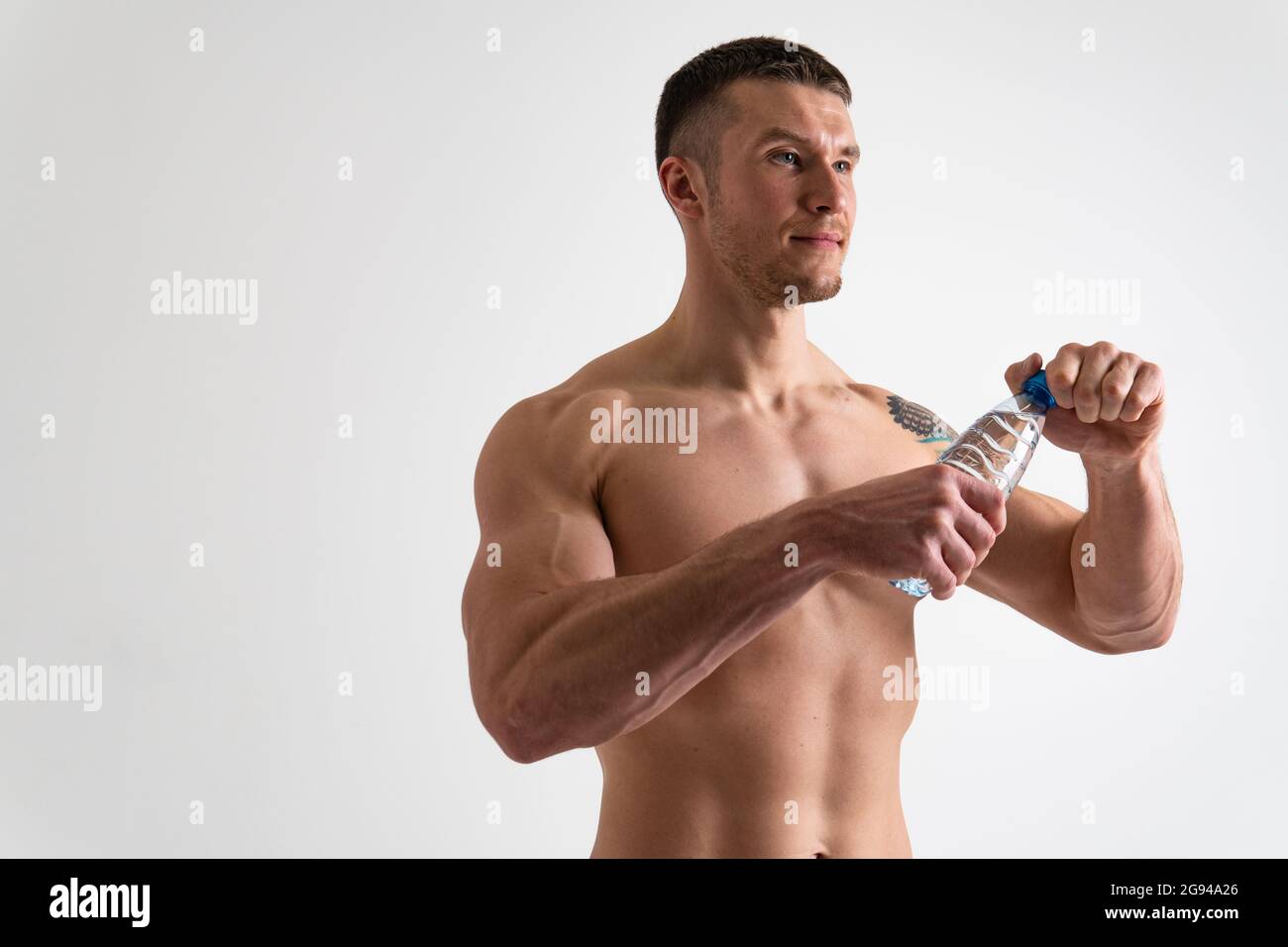 La forme physique masculine de l'eau potable est pompée avec une serviette sur un fond blanc isolé forte santé, boire exercice homme nutrition personne, arrière-plan Bodyb Banque D'Images