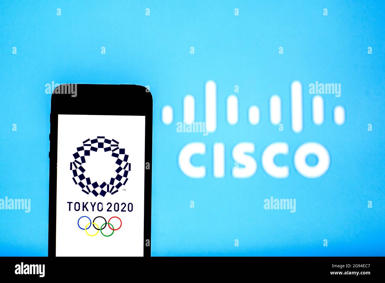 Sur cette photo, un logo des Jeux Olympiques de Tokyo de 2020 apparaît sur un smartphone avec un logo Cisco Systems, Inc. En arrière-plan. Banque D'Images