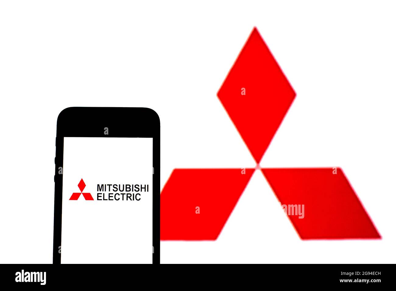 Sur cette photo, un logo Mitsubishi Electric Corporation apparaît sur un smartphone avec un logo Mitsubishi en arrière-plan. Banque D'Images