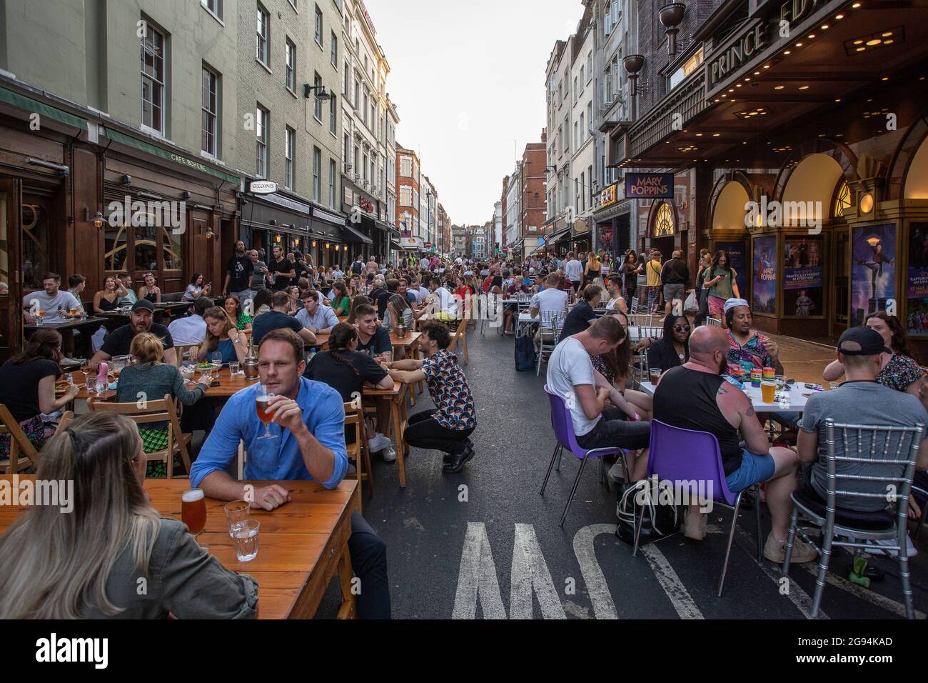 Les gens qui apprécient la nourriture et les boissons en plein air dans le centre de Londres comme Covid restrictions sont assouplies dans Old Compton Street , Soho, Londres , Royaume-Uni . Banque D'Images