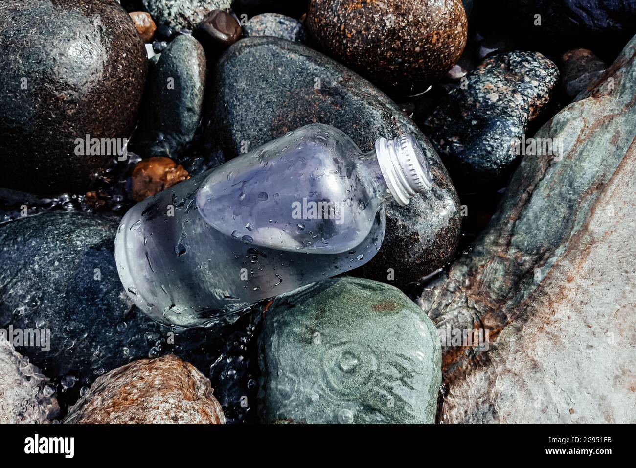 Belle bouteille d'eau sur les rochers de la mer. Banque D'Images