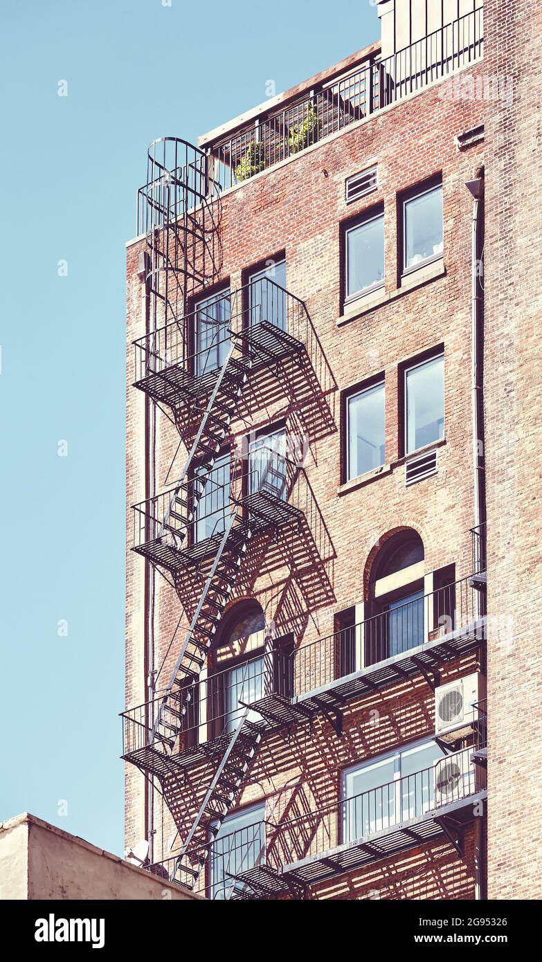 Vieux bâtiment en brique avec évacuation de feu à New York, couleurs appliquées, Etats-Unis. Banque D'Images