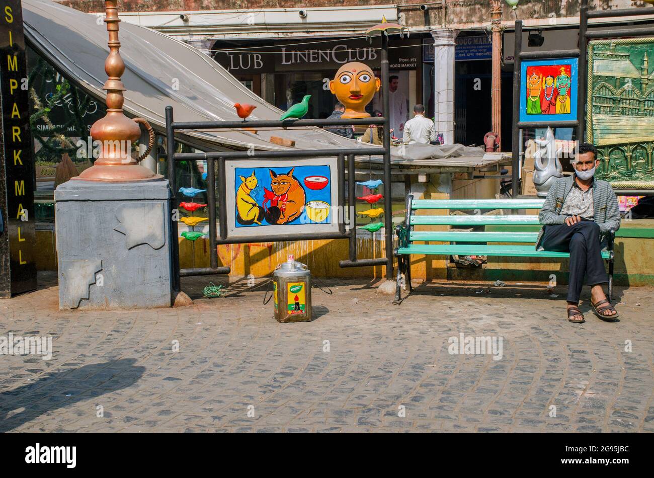 Voici une sculpture de peinture à vendre dans la région du Nouveau marché de ​​Kolkata. Une des personnes est assise sur le banc pour profiter du soleil. Banque D'Images