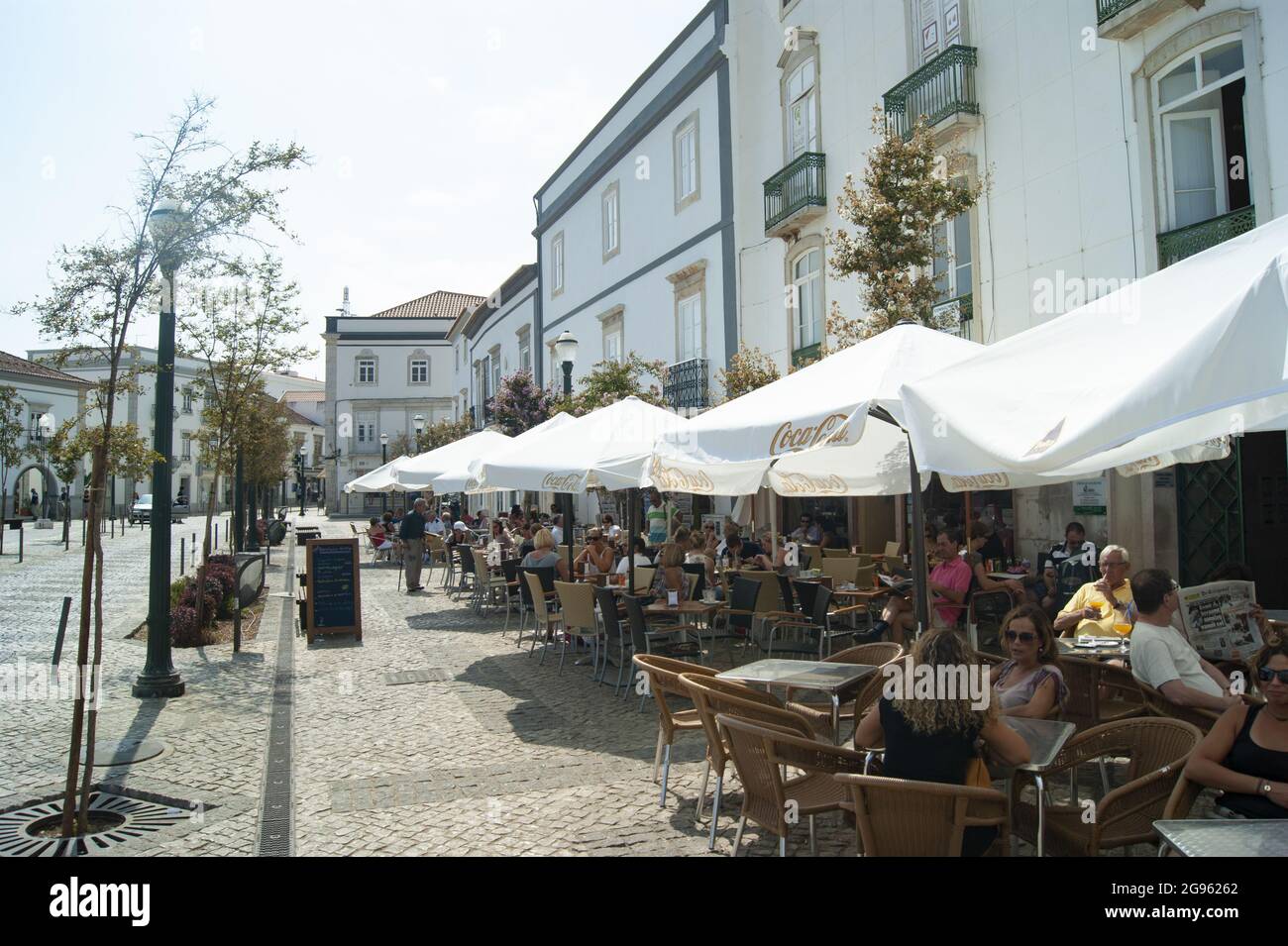 Tavira / Portugal / septembre 21 2012 : les vacanciers apprécient les boissons et la nourriture dans un café situé sur le trottoir au cœur de la vieille ville. Des parasols sont à votre disposition Banque D'Images