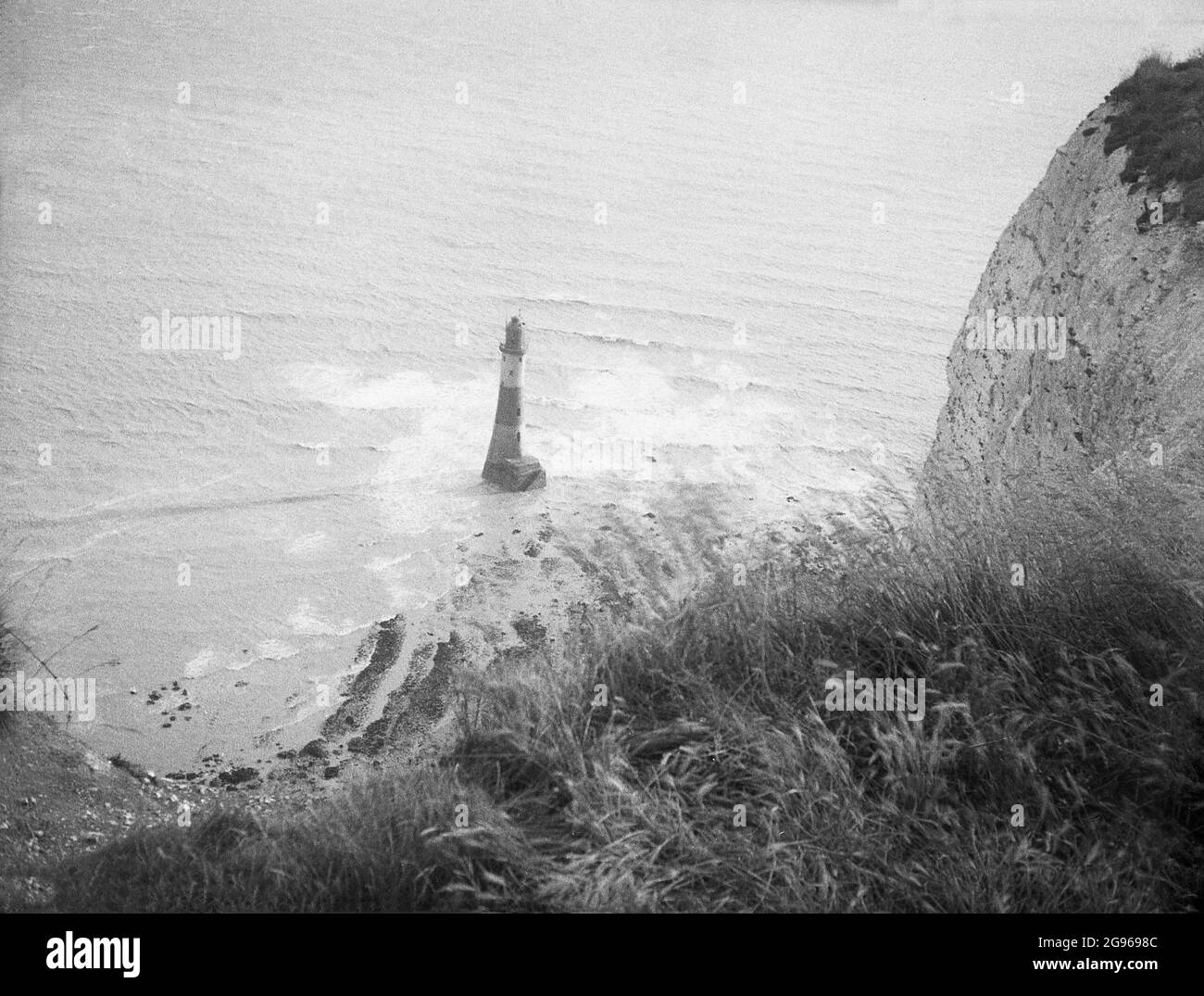 1950s, historique, le phare offshore au pied de la baie à Beachy Head, une célèbre pointe sur les South Downs à Eastbourne, East Sussex, Angleterre, Royaume-Uni. Une tour en granit, érigée en 1902 pour remplacer le phare Belle Tour au sommet des falaises, c'était la dernière « tour de roche » de style traditionnel à être construite en Angleterre. La plus haute falaise de la mer de craie en Grande-Bretagne, Beachy Head et ses vallons environnants sont un endroit magnifique pour la marche de plaisir. En 1929, par une loi du Parlement, les terres des South Downs ont été achetées pour protéger leur utilisation pour les générations futures. Banque D'Images