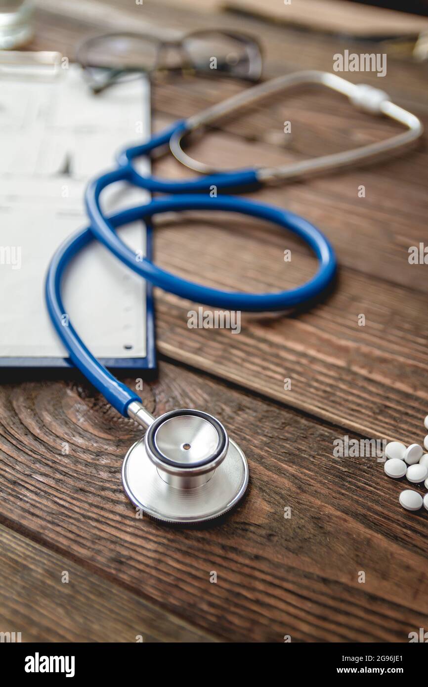 carte médicale du patient en gros plan, stéthoscope et pilules sur le bureau du médecin Banque D'Images