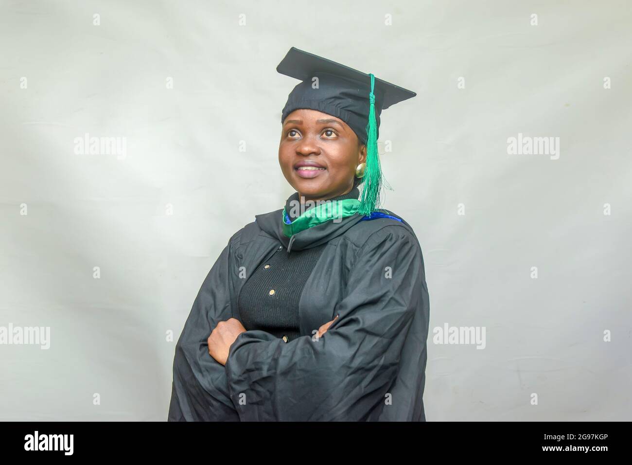 Portrait d'une femme africaine heureuse finissant ou finissant des étudiants souriant dans sa tenue noire Banque D'Images