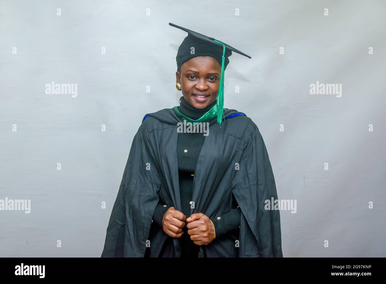 Portrait d'une femme africaine heureuse finissant ou finissant des étudiants souriant dans sa tenue noire Banque D'Images