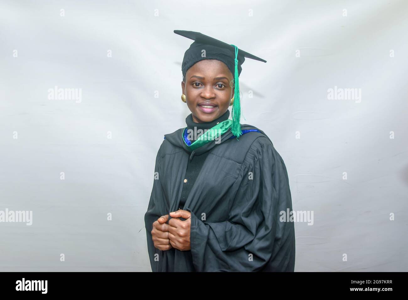 Portrait d'une femme africaine heureuse finissant ou finissant des étudiants souriant dans sa tenue noire Banque D'Images