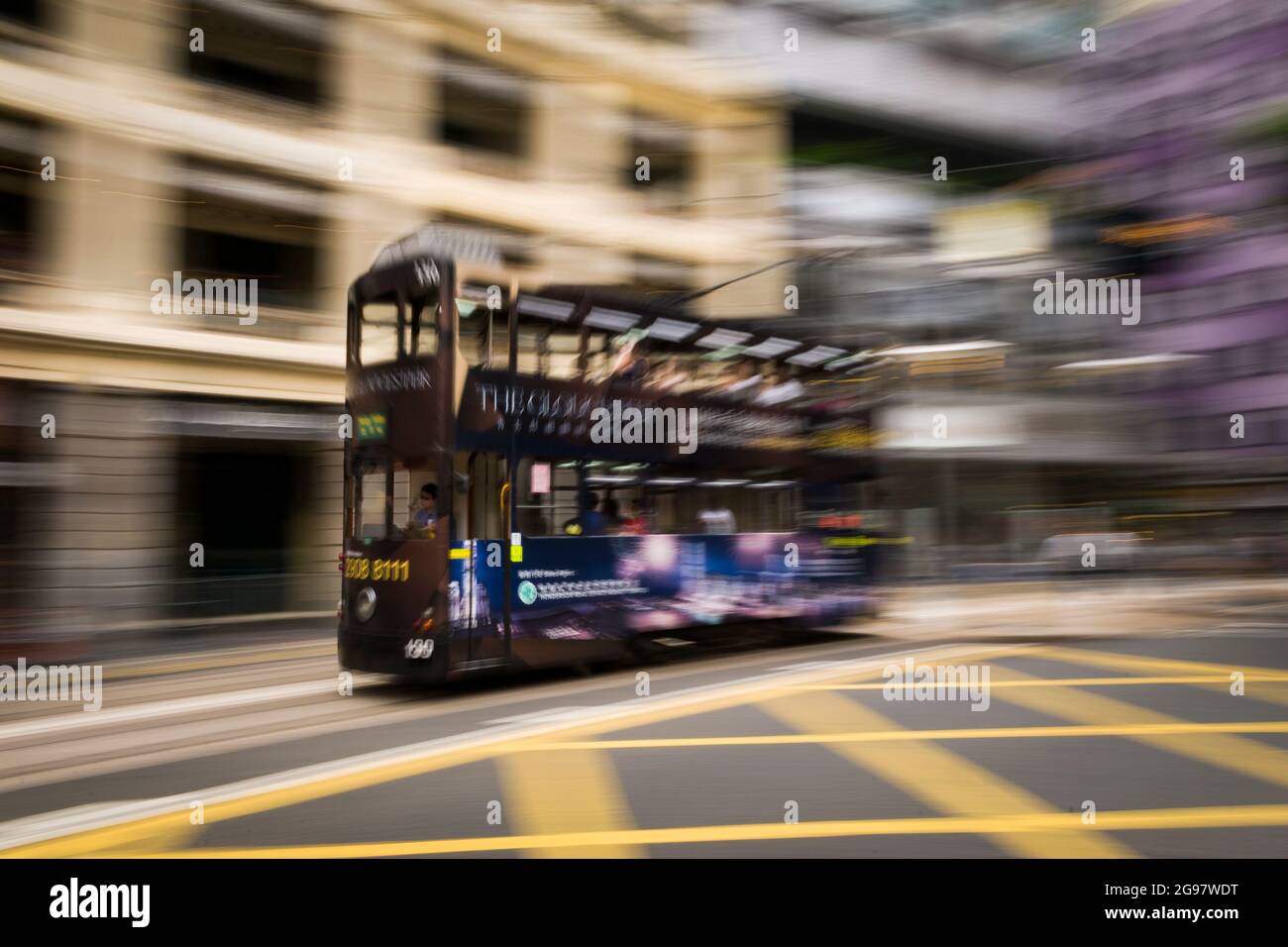 Un tramway passe devant le Pawn, un bâtiment rénové de « Tong lau » ou de centre commercial à WAN Chai, sur l'île de Hong Kong, dans un panoramique avec flou de mouvement sélectif Banque D'Images