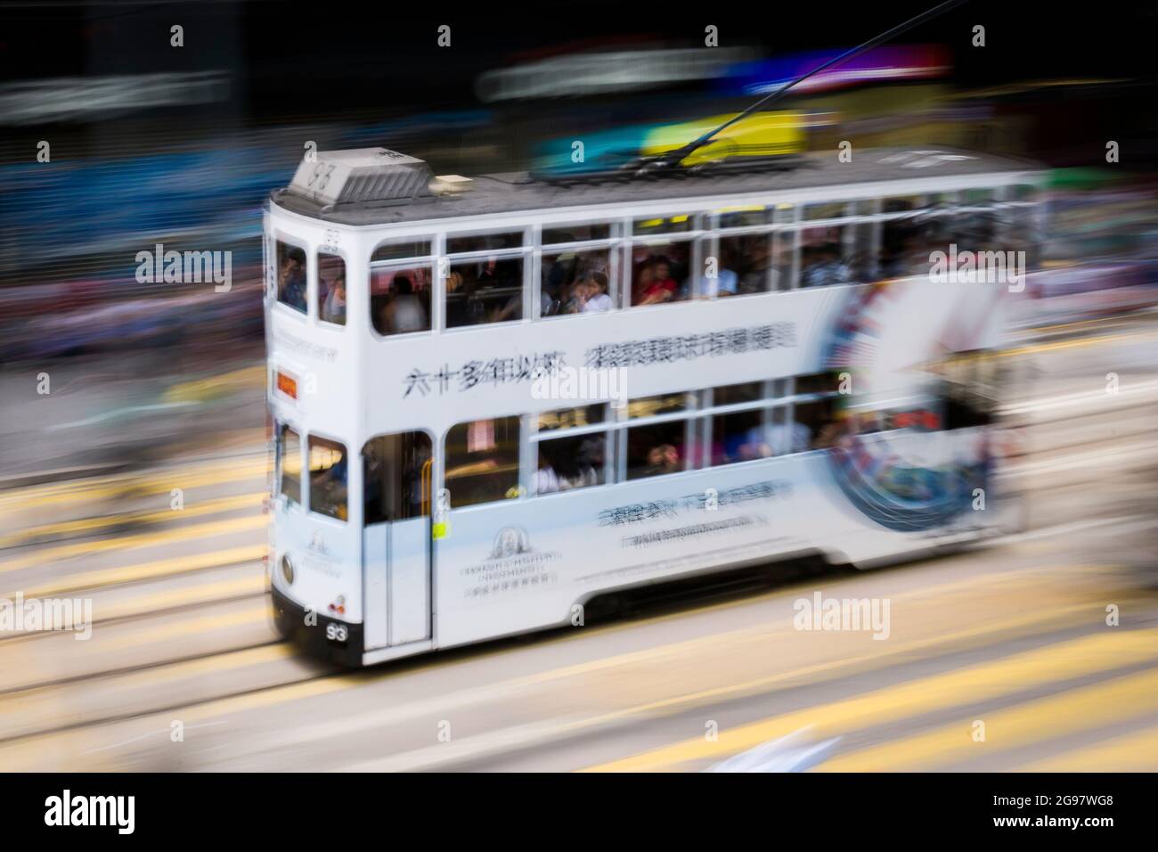 Un tramway se déplace le long de la route des Voeux, dans le centre de l'île de Hong Kong, dans un panoramique avec un flou de mouvement sélectif dû au mouvement de la caméra Banque D'Images