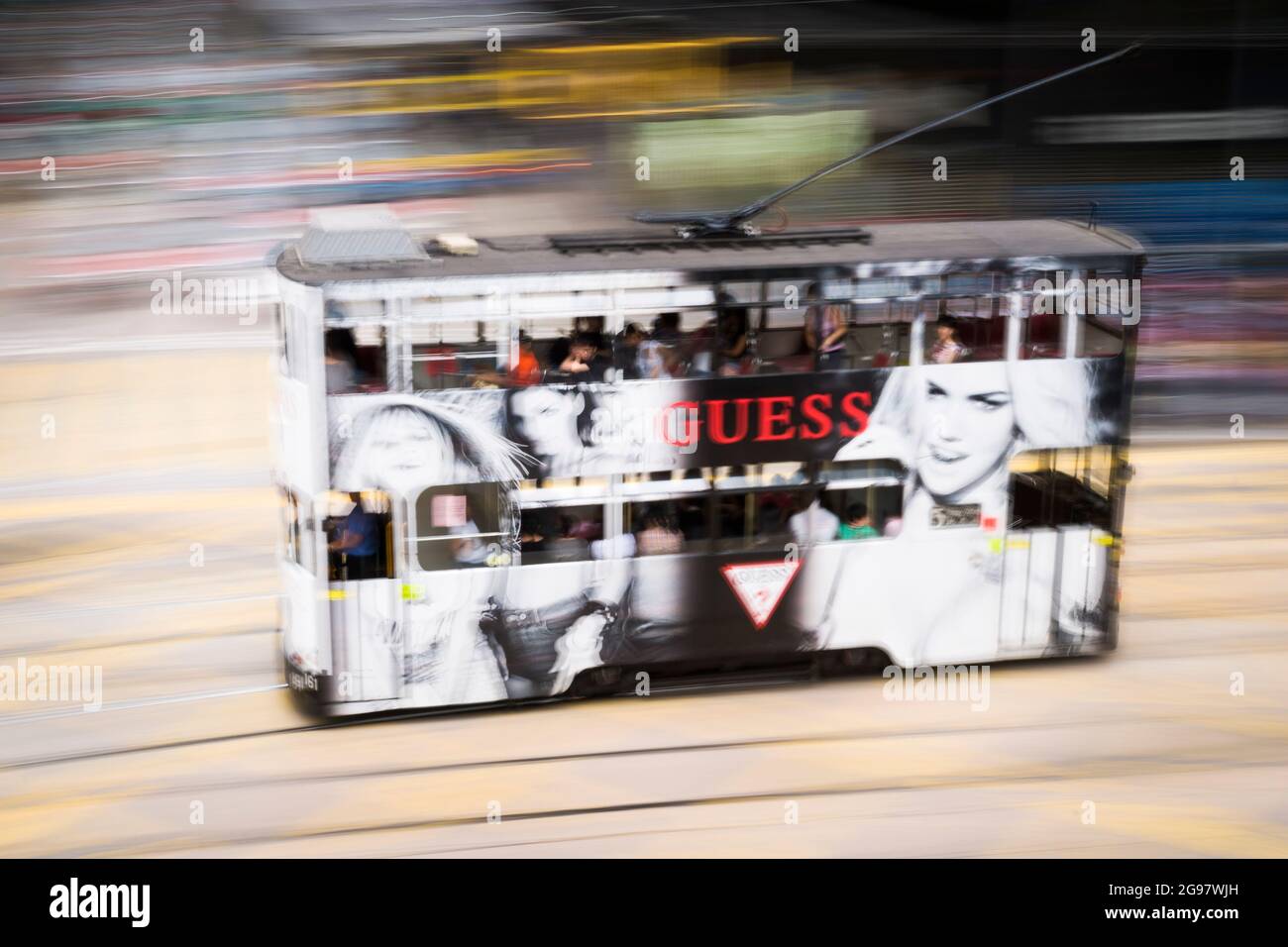 Un tramway se déplace le long de la route des Voeux, dans le centre de l'île de Hong Kong, dans un panoramique avec un flou de mouvement sélectif dû au mouvement de la caméra Banque D'Images