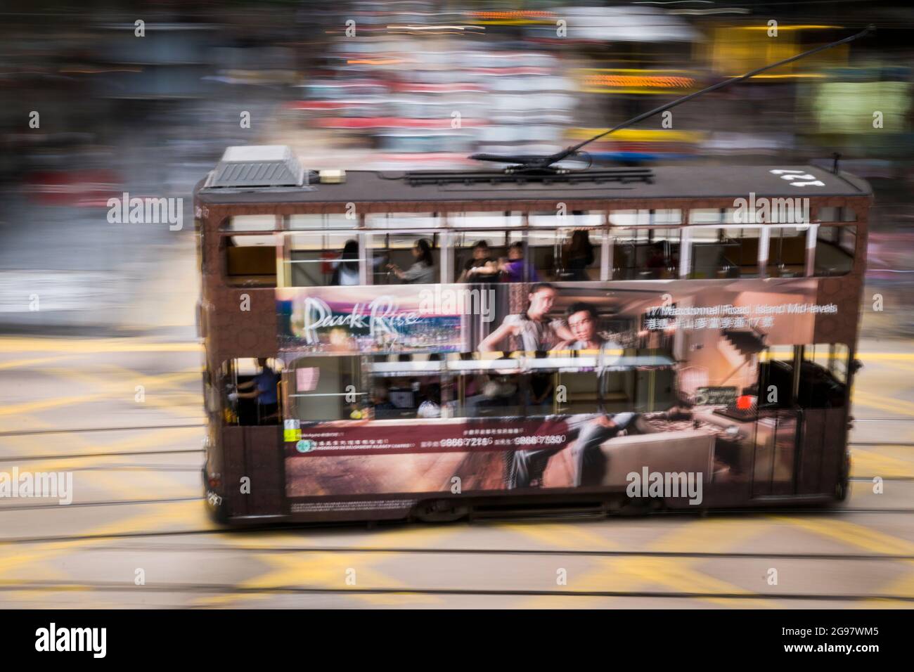 Un tramway traverse Pedder Street lorsqu'il se déplace le long de la route des Voeux, au centre, sur l'île de Hong Kong, dans un panoramique avec flou de mouvement sélectif Banque D'Images