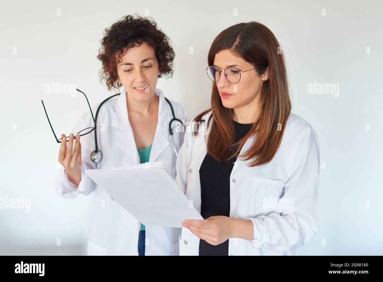 Deux femmes médecins examinent les documents et discutent d'un diagnostic Banque D'Images