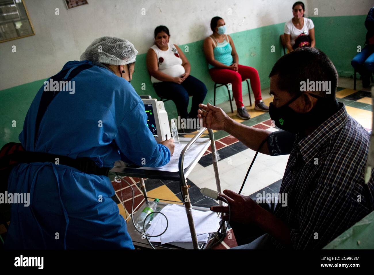 Une infirmière prend les paramètres vitaux d'un homme alors que des personnes se trouvent à San Jose de la Montaña - Norte de Santander, en Colombie, font l'objet de tests rapides et le nouveau coronavirus Jansen Johnson & Johnson (COVID-19) le 12 juillet 2021. Banque D'Images