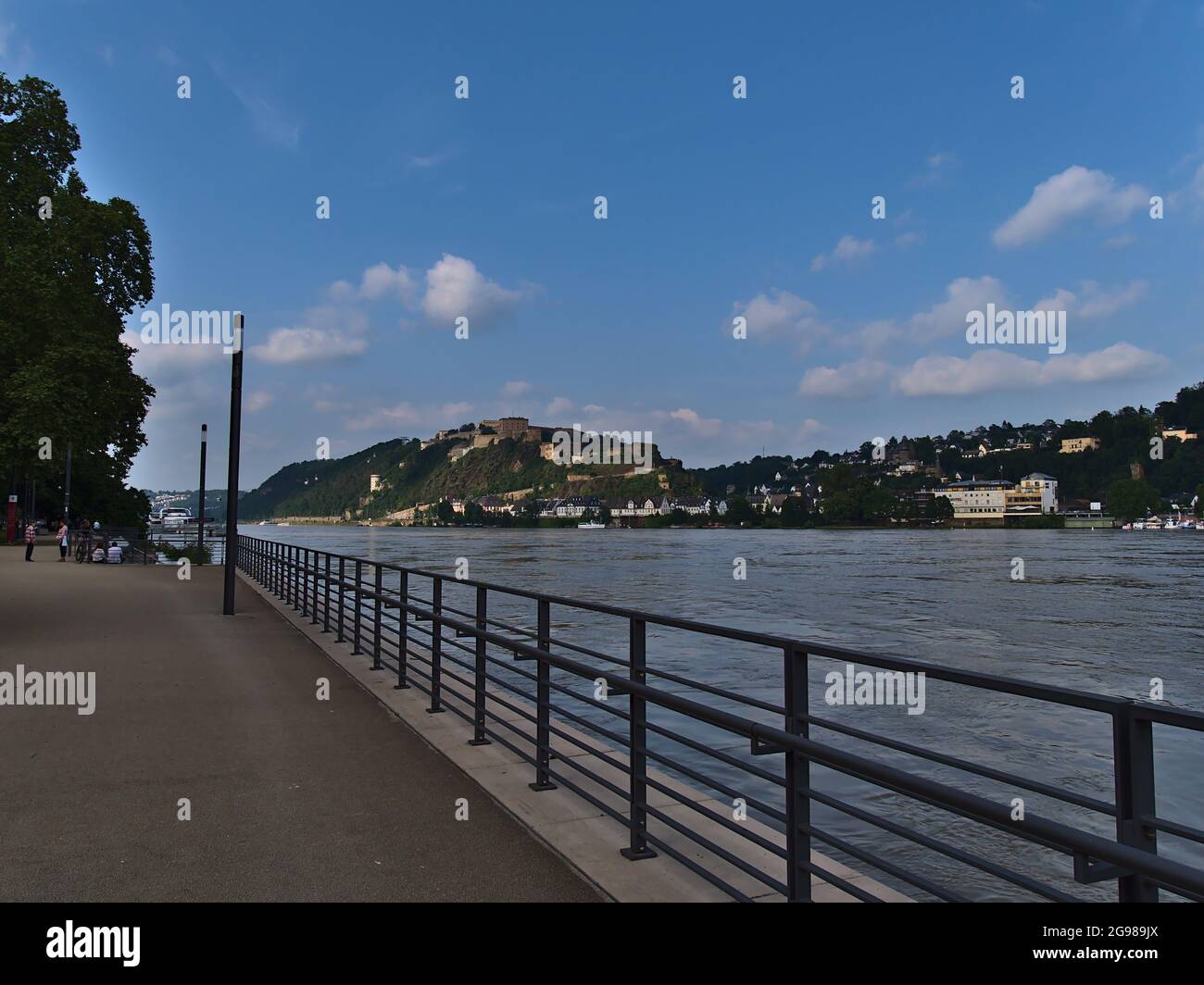 Promenade inondée au bord de la rivière dans la ville de Koblenz avec le Rhin au niveau de l'eau élevé le jour ensoleillé d'été avec la forteresse de main-d'eau en métal Ehrenbreitenstein. Banque D'Images