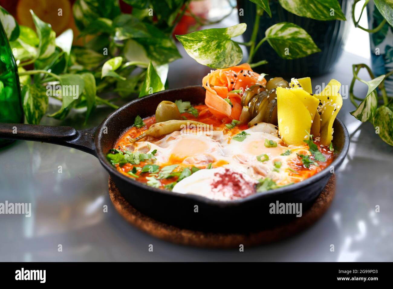 Shakshouka, oeufs frits dans une casserole avec des légumes et des tomates.Petit déjeuner, œufs avec légumes servis dans une casserole. Banque D'Images