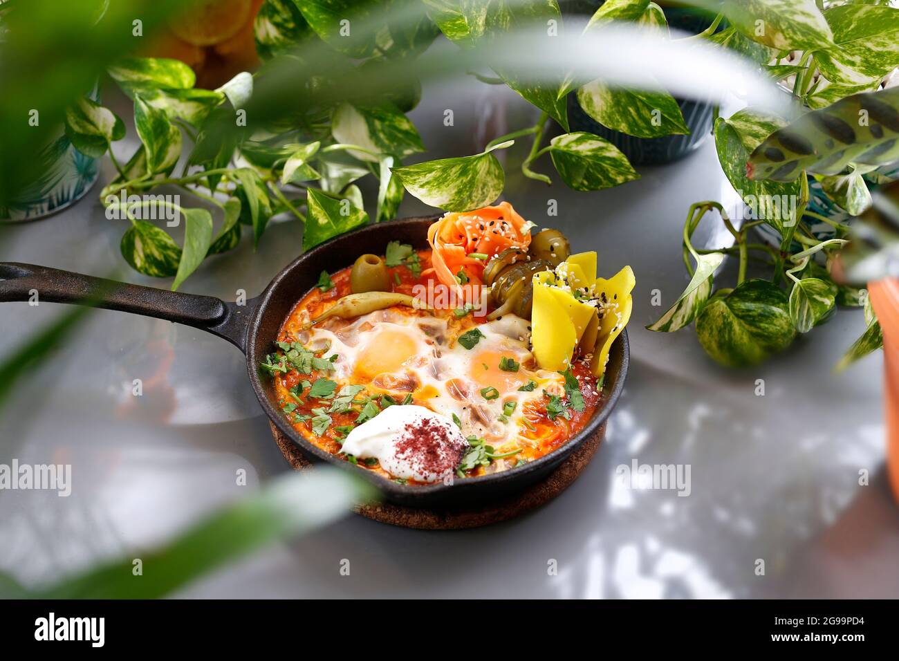 Shakshouka, oeufs frits dans une casserole avec des légumes et des tomates.Petit déjeuner, œufs avec légumes servis dans une casserole. Banque D'Images