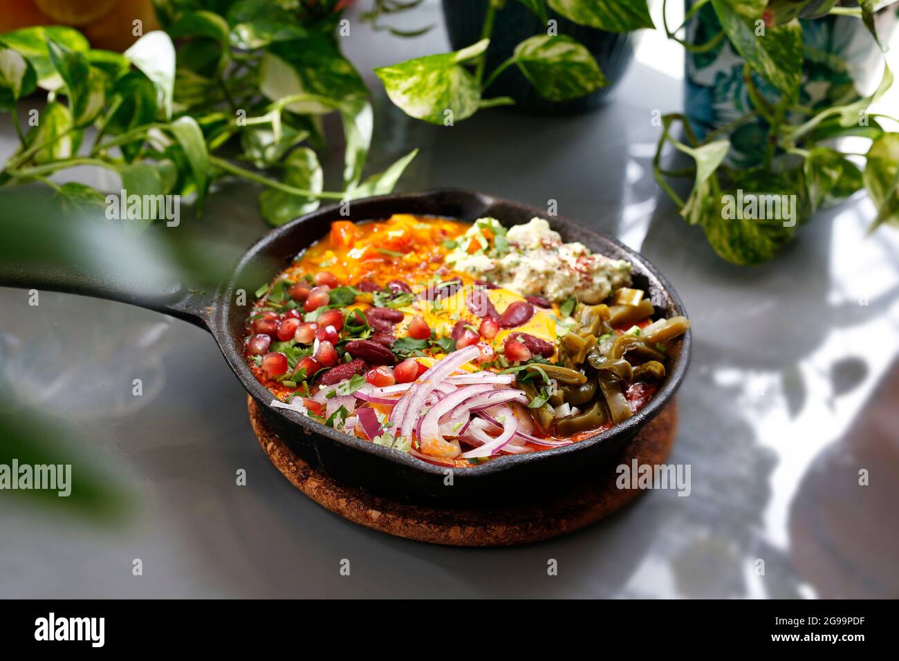Shakshouka, oeufs frits dans une casserole avec des légumes et des tomates.Petit déjeuner, œufs avec légumes servis dans une casserole. Banque D'Images