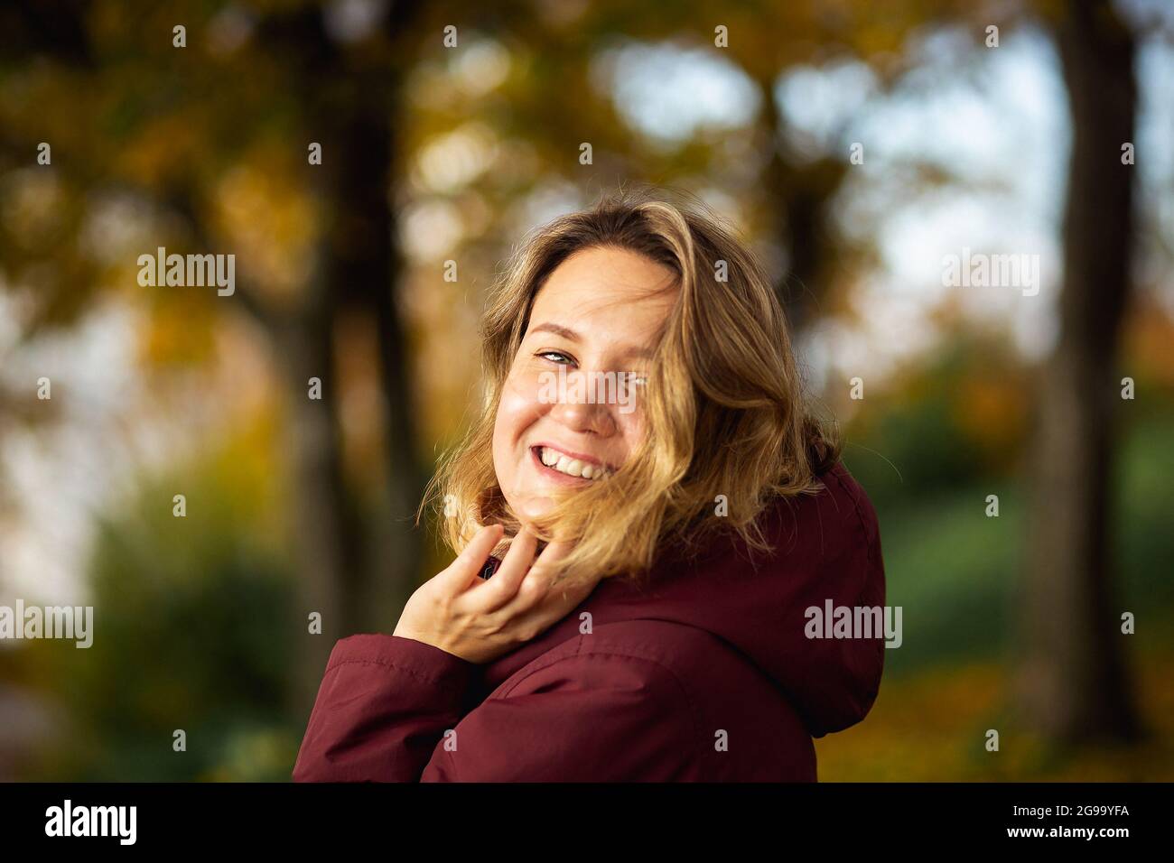 Personnes, sentiments, concept de datation saisonnière. Jeune femme ludique appréciant les feuilles jaunes d'automne dans le parc d'automne. Banque D'Images