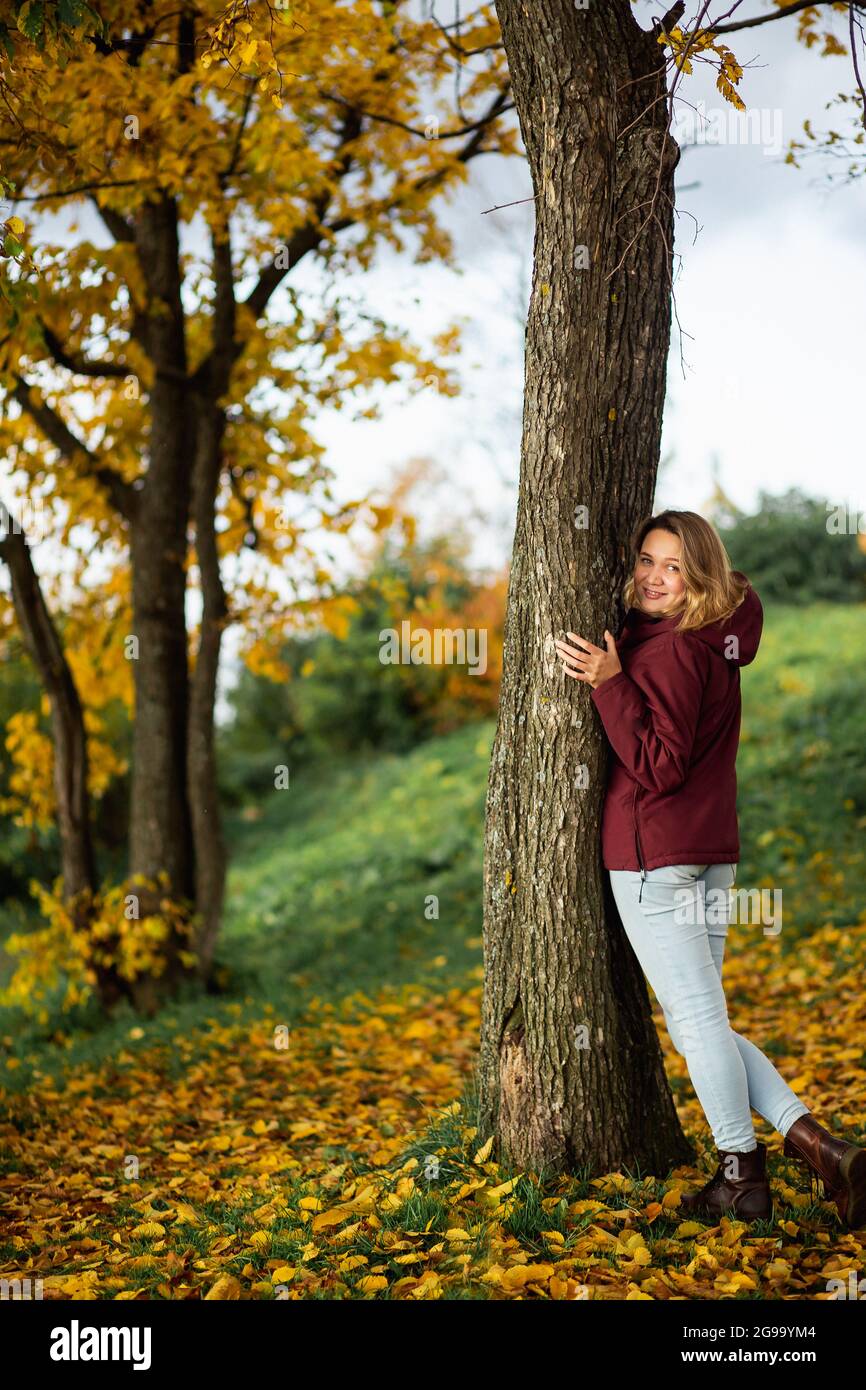 Personnes, sentiments, concept de datation saisonnière. Jeune femme ludique appréciant les feuilles jaunes d'automne dans le parc d'automne. Banque D'Images