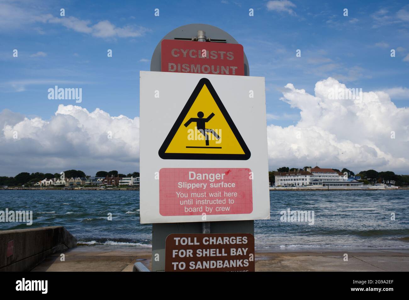 Panneaux d'avertissement les cyclistes doivent descendre danger le péage de la surface glissante facture Poole Sandbanks au ferry de la chaîne de plage Shell Poole Dorset Royaume-Uni Banque D'Images