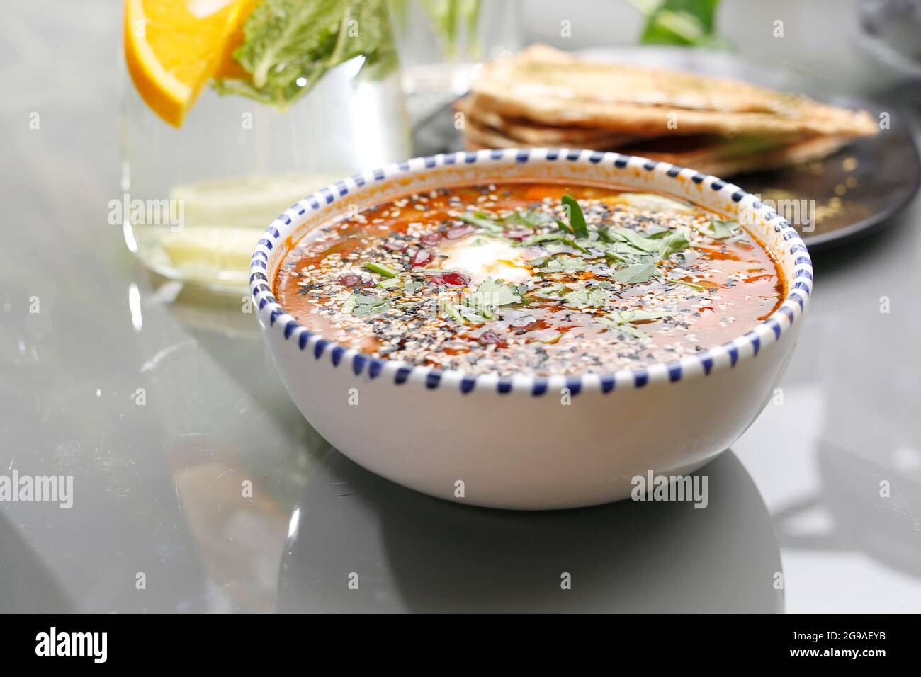 Soupe de lentilles aux tomates, à la crème aigre et aux herbes.Plats végétariens, plats colorés et appétissants. Banque D'Images