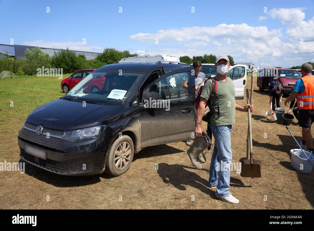 25 juillet 2021, Rhénanie-Palatinat, Grafschaft: Des bénévoles de secours aux inondations embarquèrent une navette de secours dans un parking près de Grafschaft pour les emmener dans la zone inondée le long de la rivière Ahr. Dans la vallée de l'Ahr, qui a été gravement dévastée par les inondations, les travaux de nettoyage se poursuivent sans relâche. Photo: Thomas Frey/dpa - ATTENTION: Les plaques d'immatriculation ont été pixélisées pour des raisons juridiques Banque D'Images