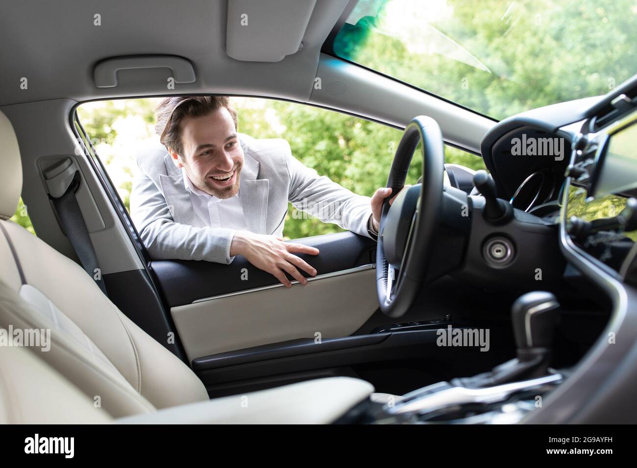 Client satisfait. Guy regardant l'intérieur de voiture, choisissez une nouvelle voiture dans le magasin de la concession Banque D'Images