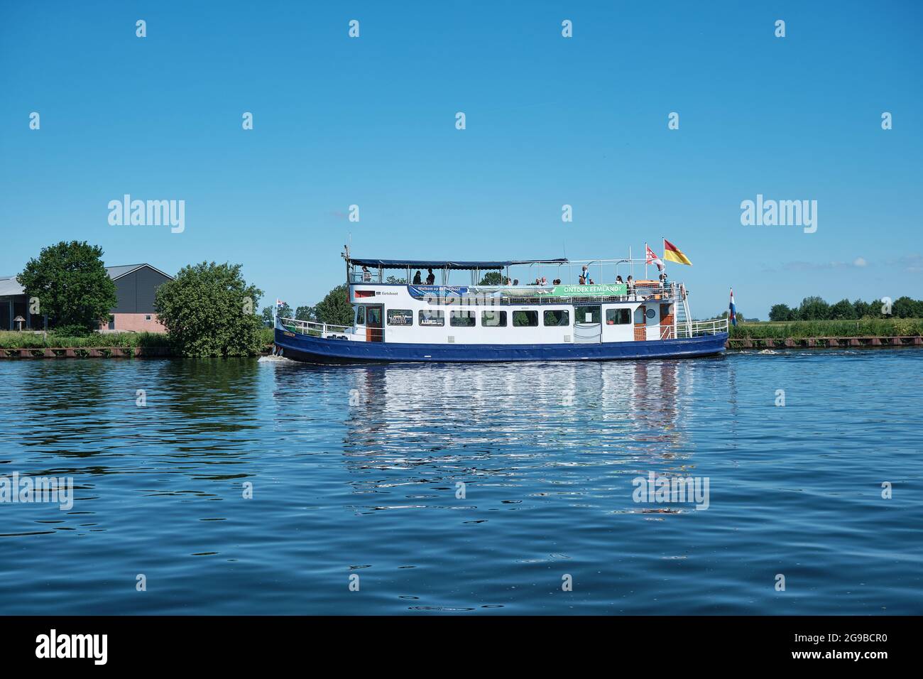 Amersfoort, Hoogland, pays-Bas 13 juin 2021, bateau à vélo, ferry eemland sur la rivière EEM avec des passagers et une digue et un ciel bleu dans le Banque D'Images