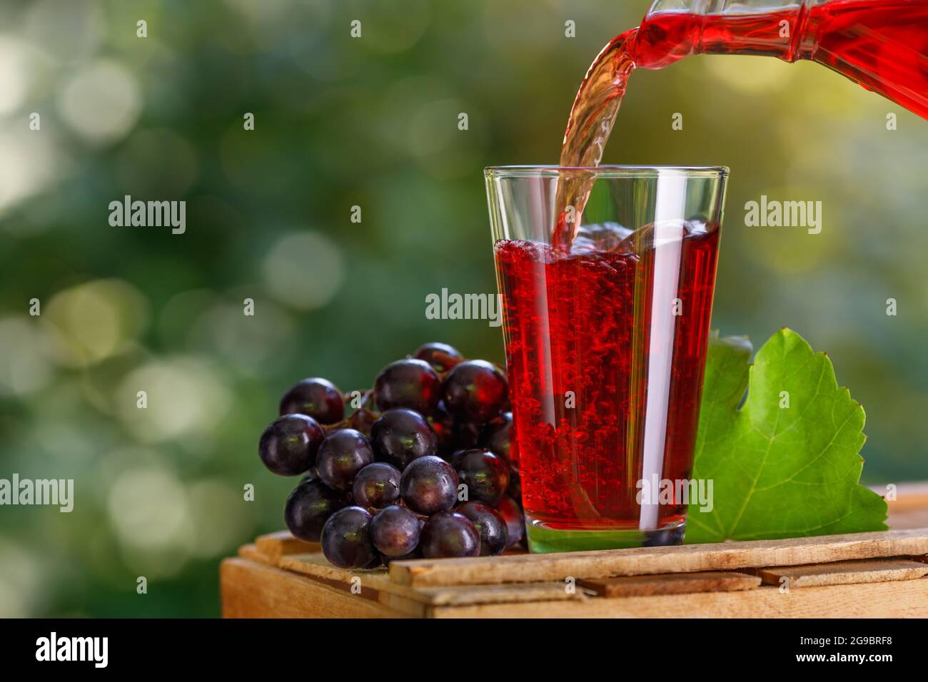 jus de raisin versé dans le verre à partir du pichet Banque D'Images