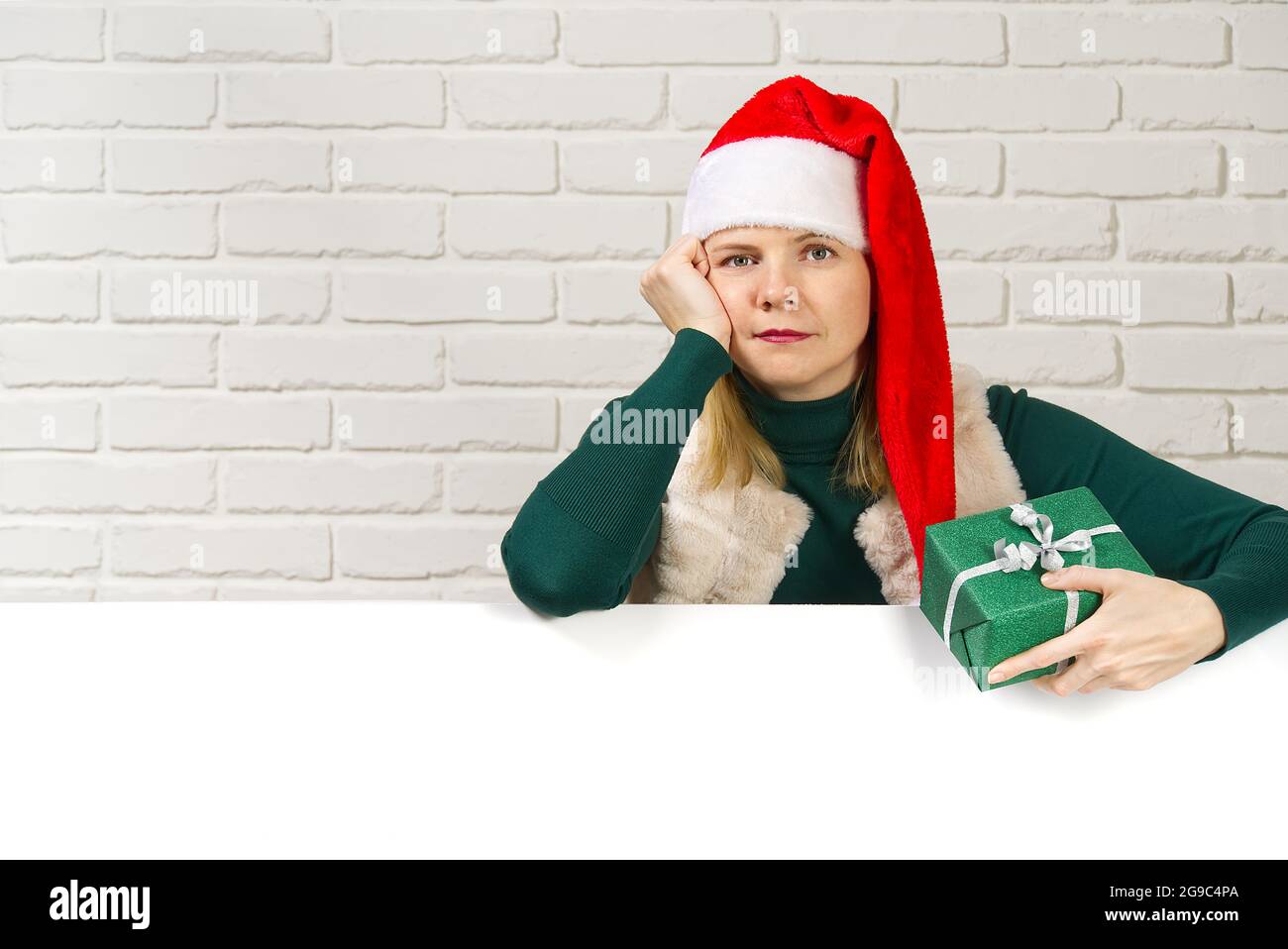 femme dans un chapeau de gnome rouge et un cadeau dans ses mains Banque D'Images