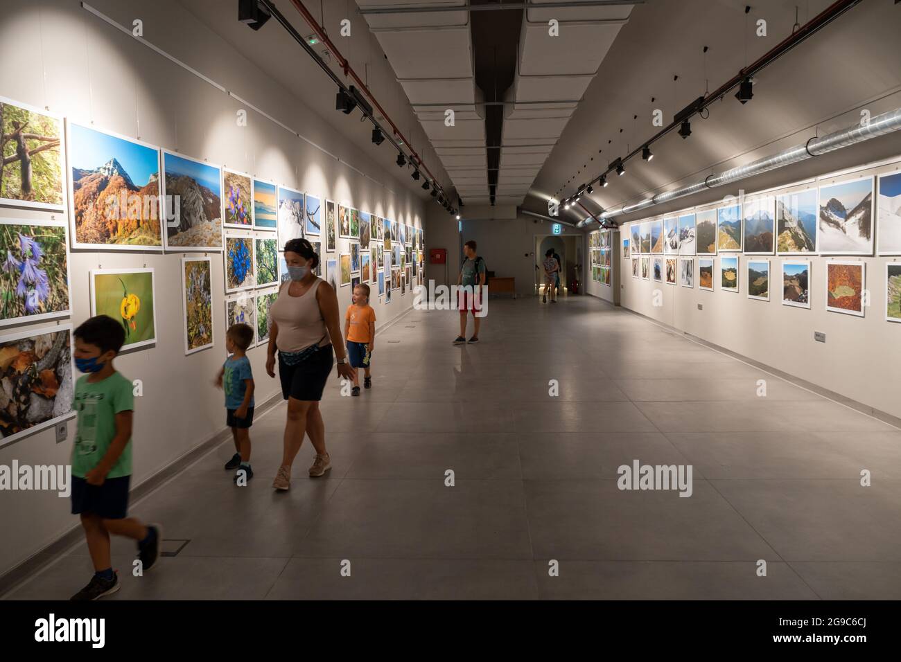STARI GRAD, CROATIE - 18 juillet 2021 : la femme et les enfants qui marchent dans un hall avec des photos suspendues dans le musée du Parc National de Paklenica Banque D'Images