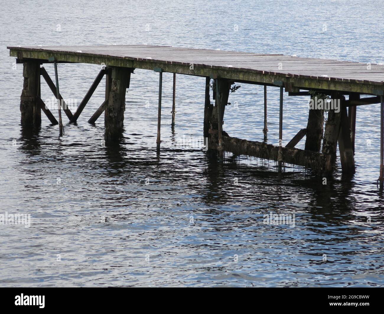 Vue rapprochée de la jetée en bois qui s'étend sur les eaux du Loch Lomond à Duck Bay Marina, une destination touristique populaire pour admirer la vue. Banque D'Images